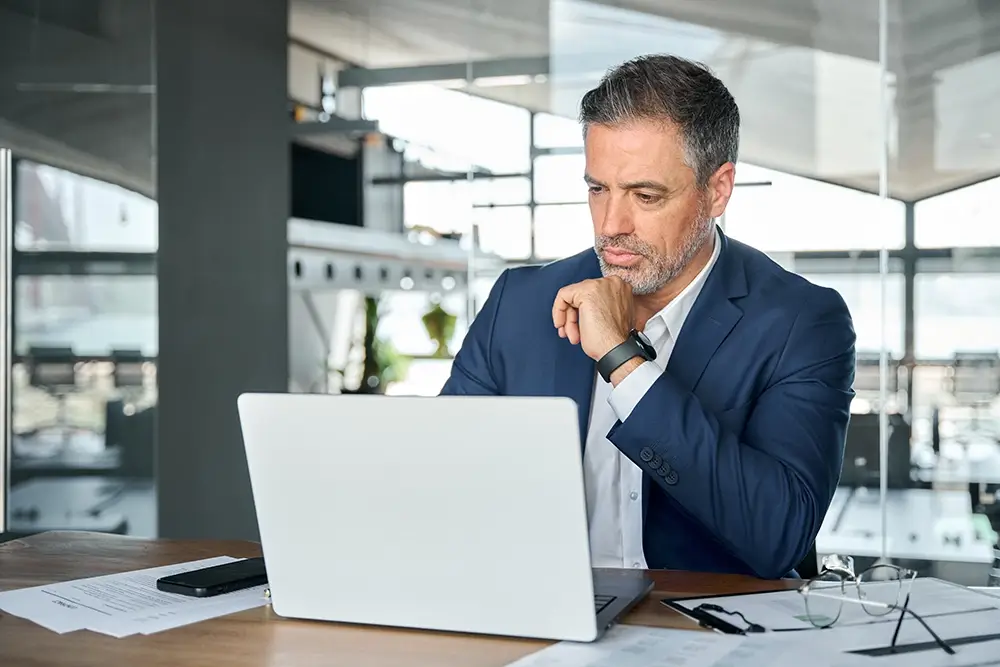 man contemplating at his laptop