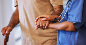 Hands of female medical worker and male with hospice care.