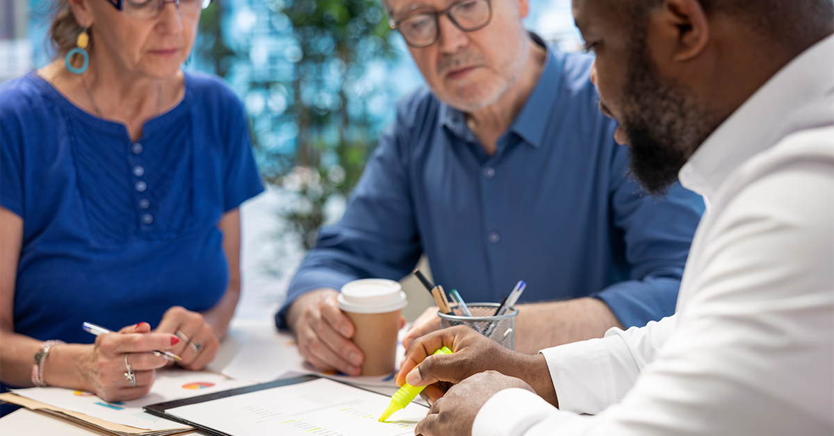 Insurance broker highlighting the important contract terms, discussing with senior couple