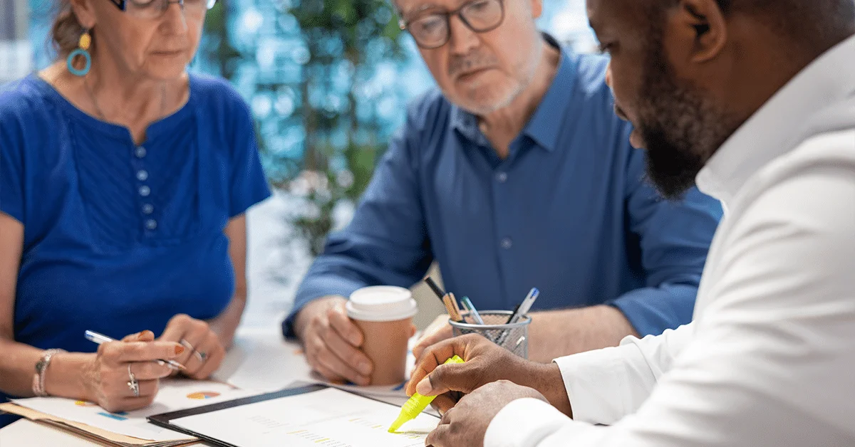 Insurance broker highlighting the important contract terms, discussing with senior couple