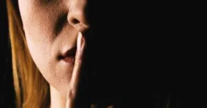 woman with index finger on her lips
